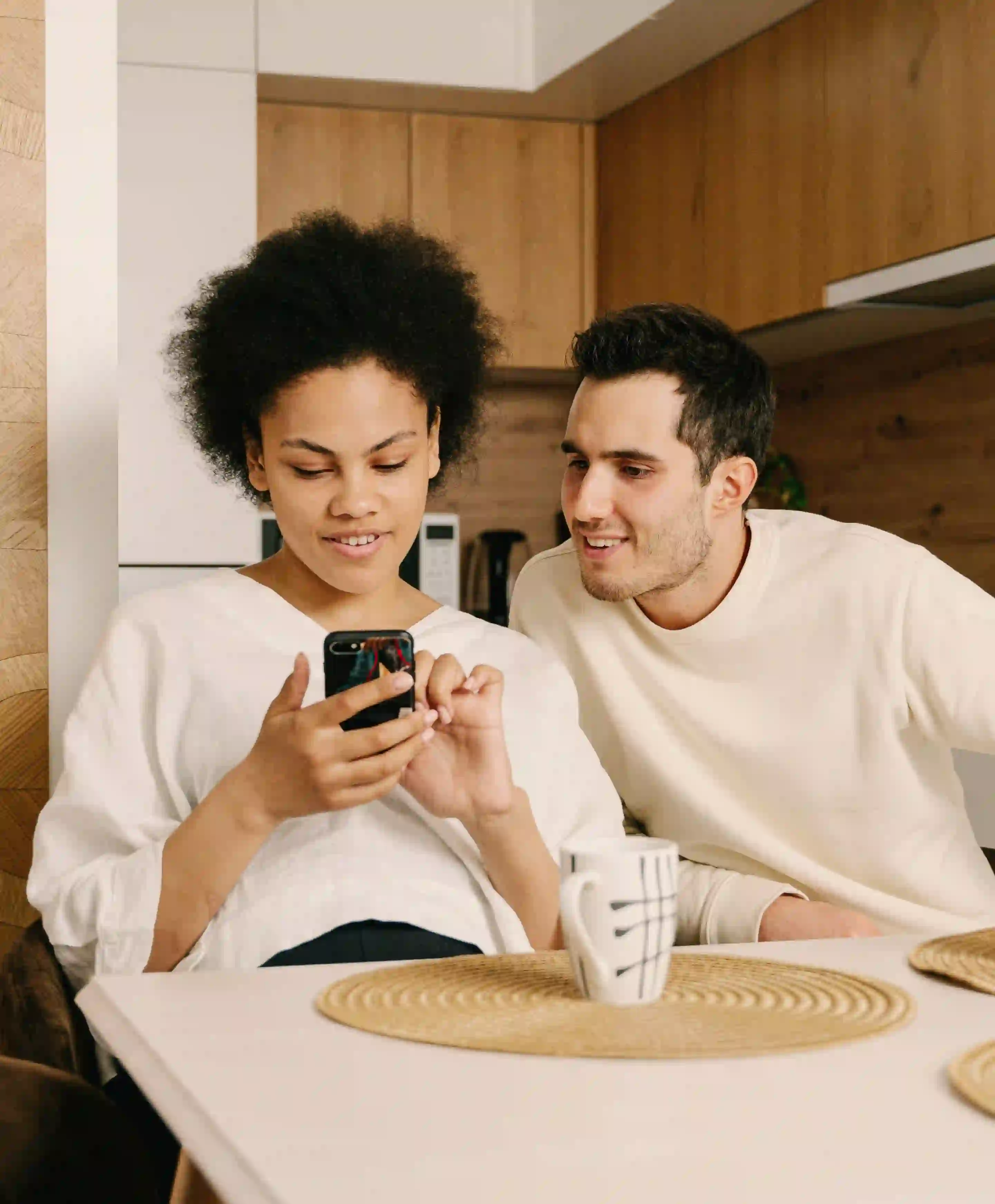 Two people sitting at a table looking at a phone with a notification from Pip.